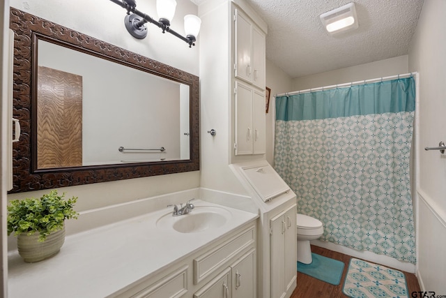 802 Carriage Dr, Tyler, TX 75703 - full bath featuring vanity, a textured ceiling, wood finished floors, and a shower with shower curtain