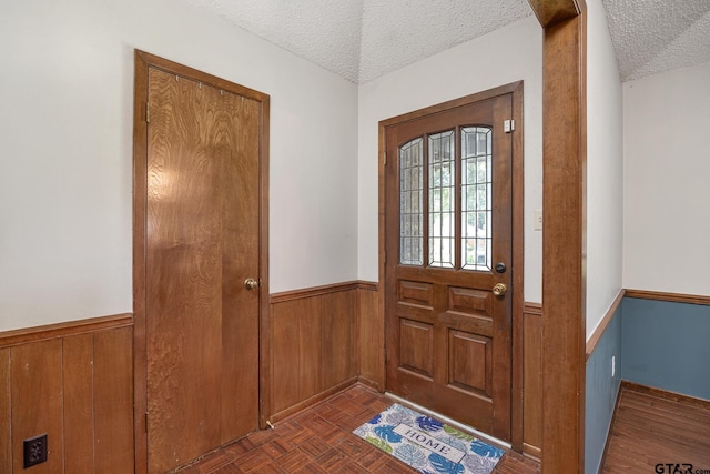 802 Carriage Dr, Tyler, TX 75703 - entrance foyer featuring a textured ceiling, wainscoting, and wooden walls