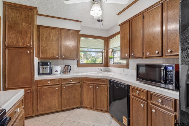 802 Carriage Dr, Tyler, TX 75703 - kitchen featuring stainless steel microwave, black dishwasher, backsplash, ceiling fan, and brown cabinetry