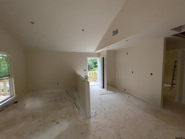 unfurnished room with high vaulted ceiling