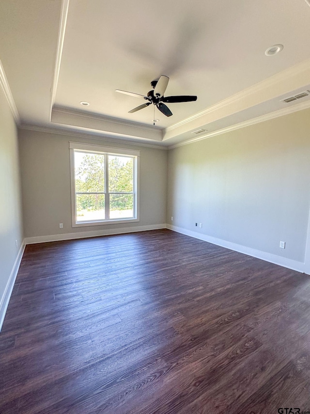 7449 Crk 314, Henderson, TX 75652 - spare room featuring a tray ceiling, ornamental molding, ceiling fan, dark wood-style floors, and baseboards