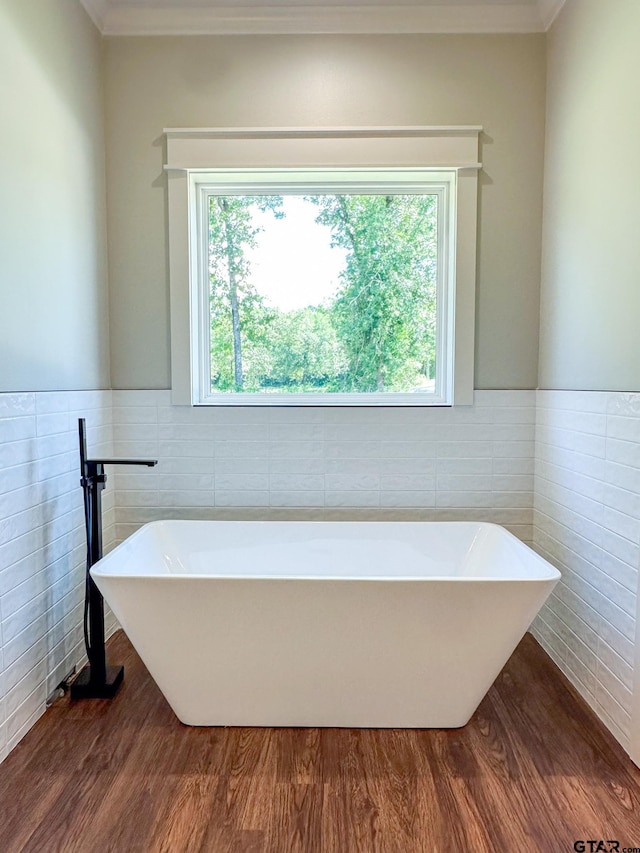 7449 Crk 314, Henderson, TX 75652 - full bath featuring tile walls, crown molding, a freestanding tub, wood finished floors, and healthy amount of natural light