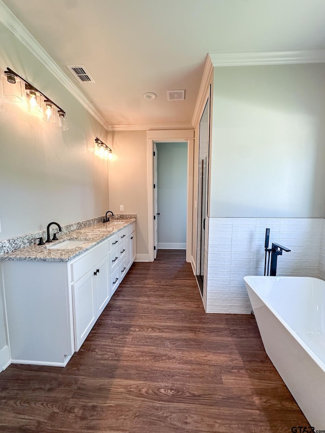 7449 Crk 314, Henderson, TX 75652 - full bathroom featuring a soaking tub, crown molding, wood finished floors, double vanity, and tile walls