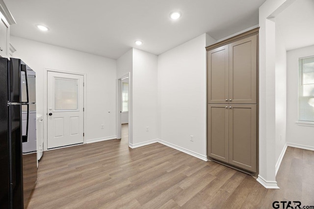 interior space with baseboards, light wood-style flooring, and recessed lighting