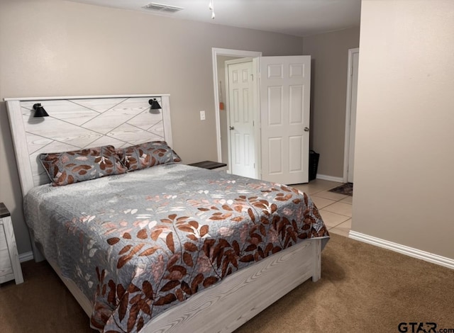 bedroom with carpet flooring, baseboards, visible vents, and tile patterned flooring