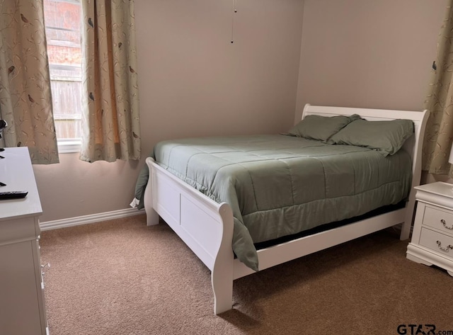 carpeted bedroom featuring baseboards