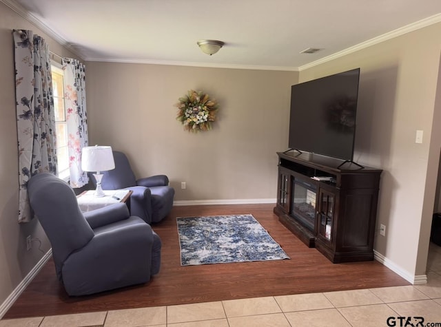 living area featuring crown molding, baseboards, and tile patterned flooring
