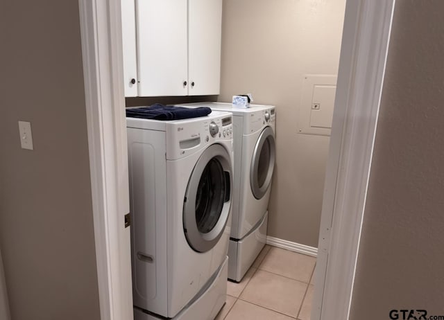 washroom with light tile patterned floors, baseboards, cabinet space, and washer and dryer