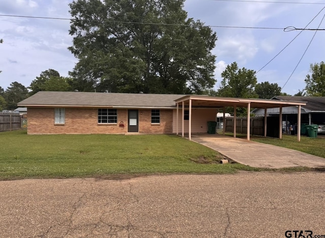 ranch-style house with fence, concrete driveway, brick siding, and a front yard