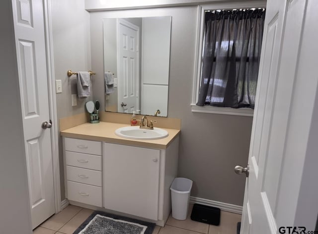 bathroom with baseboards, tile patterned flooring, and vanity
