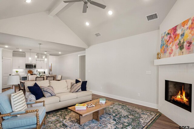 living room featuring high vaulted ceiling, beamed ceiling, hardwood / wood-style floors, and ceiling fan