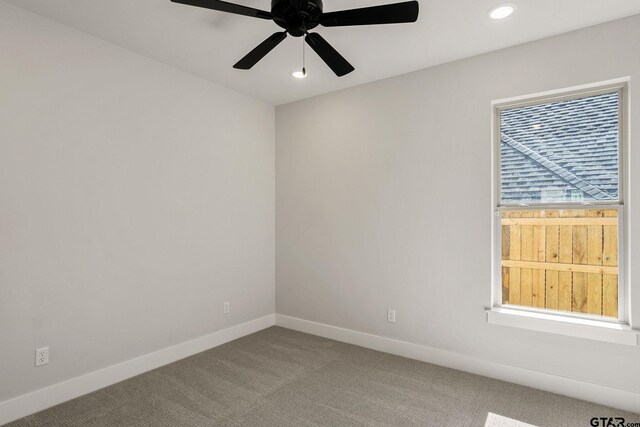 carpeted spare room featuring ceiling fan