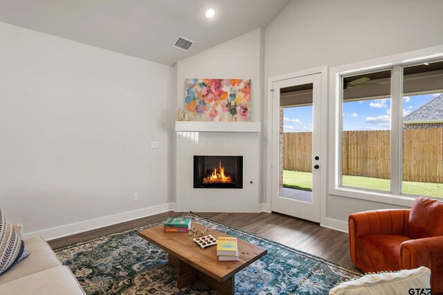 living room with dark hardwood / wood-style floors and lofted ceiling