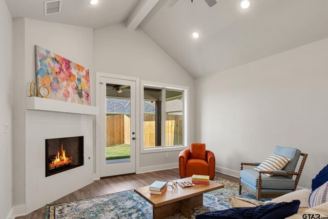 living room with high vaulted ceiling, beamed ceiling, hardwood / wood-style flooring, and ceiling fan