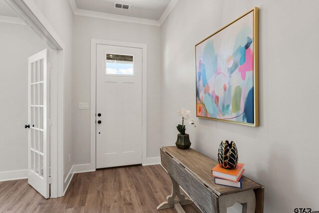 entryway featuring ornamental molding and hardwood / wood-style flooring