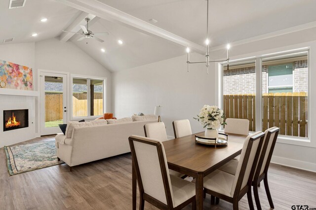 dining area with hardwood / wood-style floors, ceiling fan, and vaulted ceiling with beams