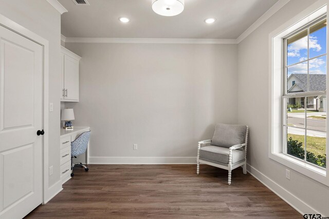 home office featuring a wealth of natural light, built in desk, and dark hardwood / wood-style floors