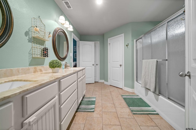 2531 Guinn Farms Rd, Tyler, TX 75707 - full bath with bath / shower combo with glass door, baseboards, double vanity, and tile patterned flooring