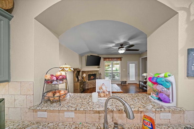 2531 Guinn Farms Rd, Tyler, TX 75707 - kitchen with a fireplace, ceiling fan, open floor plan, and wood finished floors