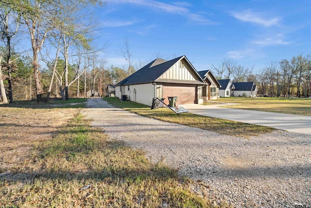 12908 County Road 463, Tyler, TX 75709 - view of property exterior with a lawn, a garage, board and batten siding, and concrete driveway