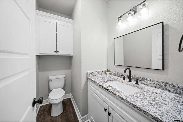 12908 County Road 463, Tyler, TX 75709 - half bathroom with toilet, baseboards, wood finished floors, and vanity