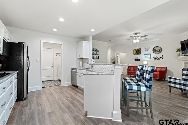 kitchen with tasteful backsplash, a breakfast bar, a peninsula, stainless steel appliances, and a sink