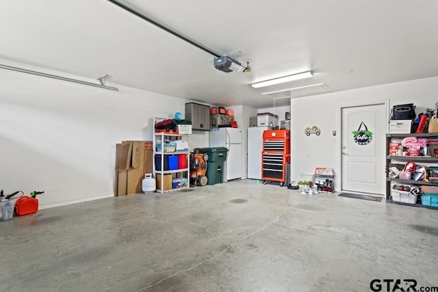 garage featuring a garage door opener and freestanding refrigerator