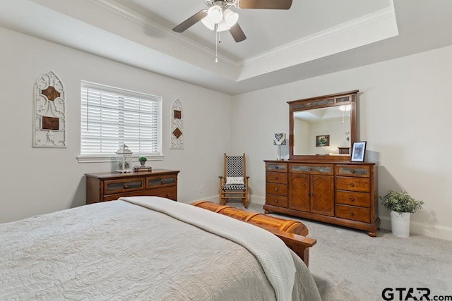 bedroom featuring baseboards, ornamental molding, a raised ceiling, and light colored carpet