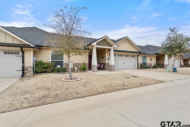 craftsman-style house with driveway, stone siding, a garage, and board and batten siding