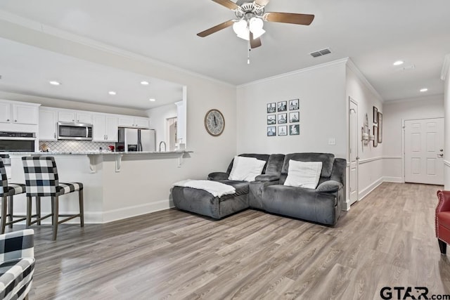 living room with light wood-style flooring, visible vents, baseboards, and recessed lighting