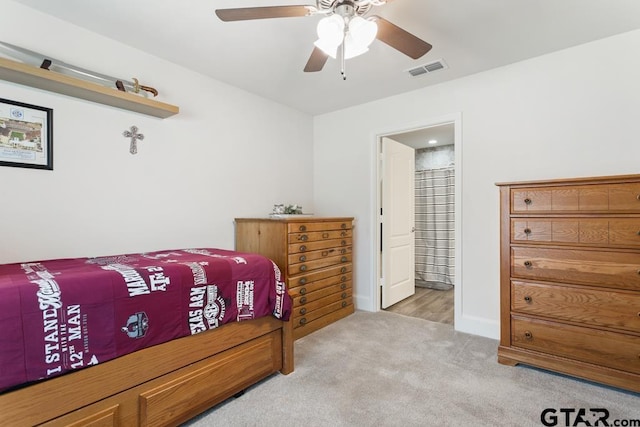 bedroom featuring ceiling fan, connected bathroom, carpet floors, visible vents, and baseboards