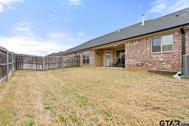 back of property featuring a yard, a fenced backyard, a patio, and brick siding