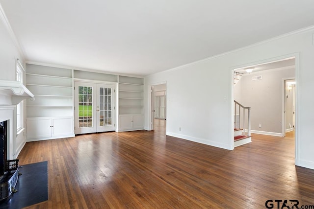 2318 S Chilton Ave, Tyler, TX 75701 - unfurnished living room with stairway, wood finished floors, built in shelves, french doors, and crown molding