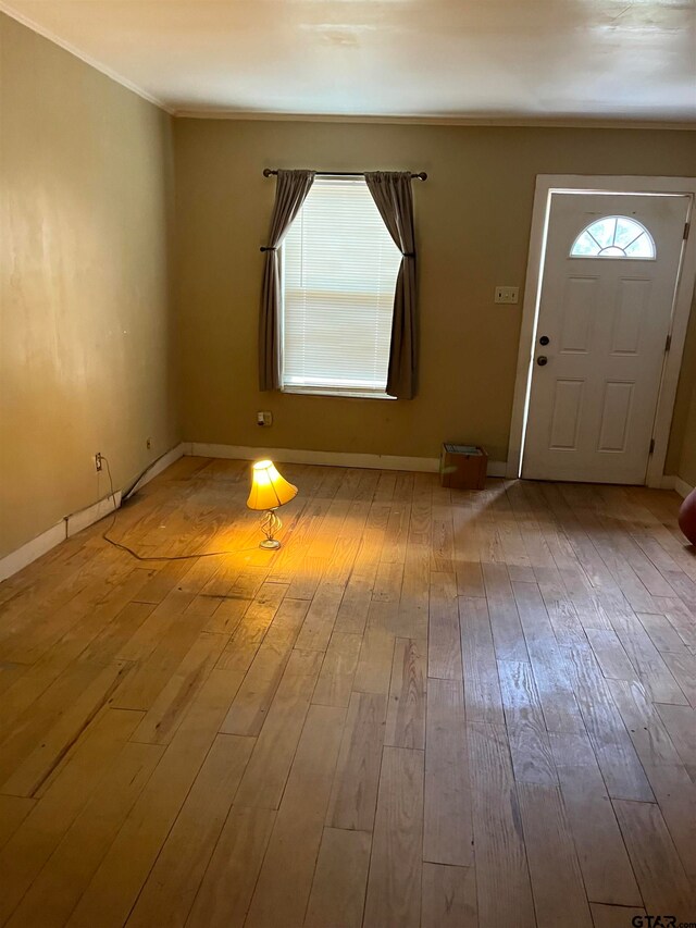 entryway with hardwood / wood-style flooring and crown molding