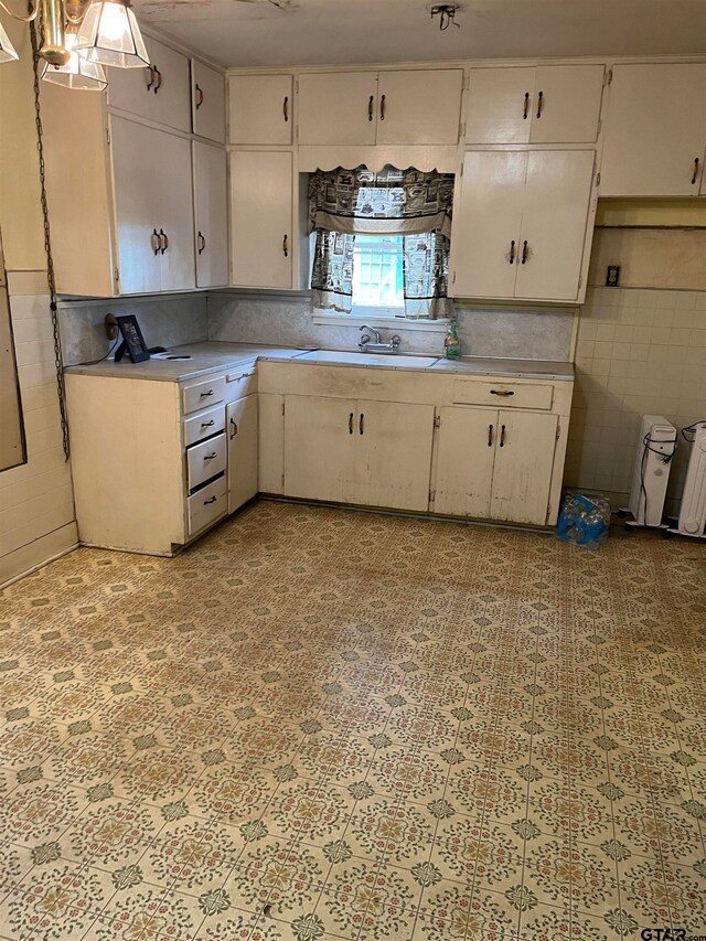 kitchen featuring white cabinetry and sink