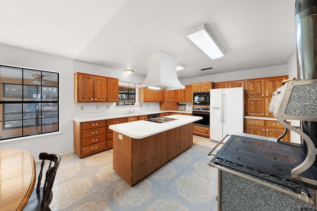 kitchen with sink, island range hood, black appliances, and a center island