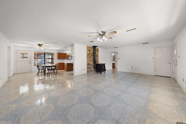 living room with ceiling fan and a wood stove