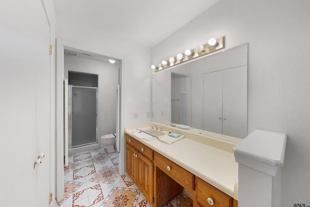 bathroom featuring toilet, tile patterned flooring, an enclosed shower, and vanity