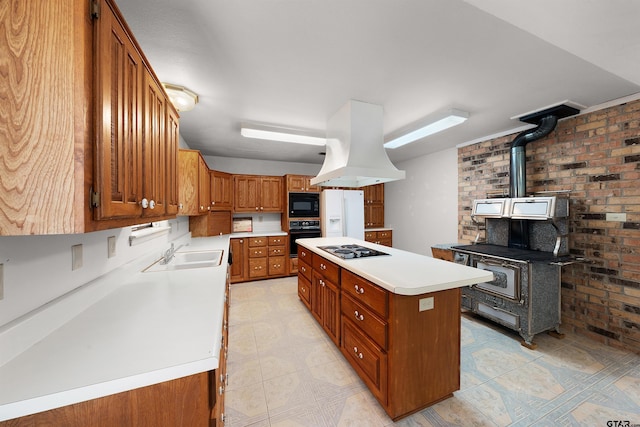 kitchen featuring island exhaust hood, a center island, brick wall, black appliances, and sink