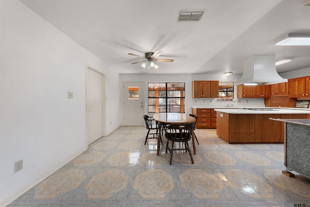 kitchen featuring island exhaust hood, ceiling fan, and a healthy amount of sunlight