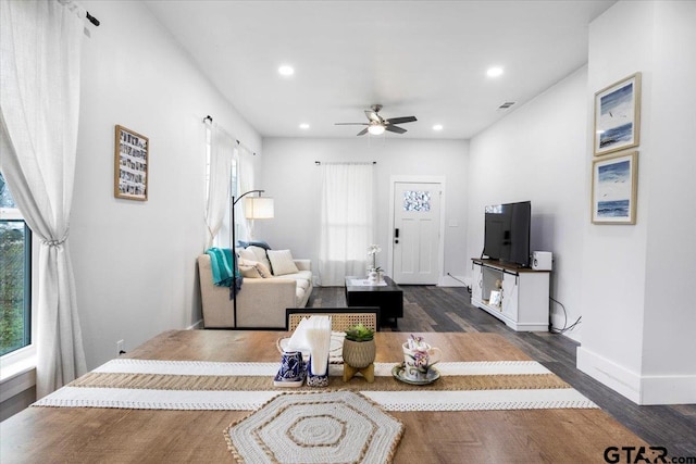 living room featuring ceiling fan, plenty of natural light, and dark hardwood / wood-style flooring