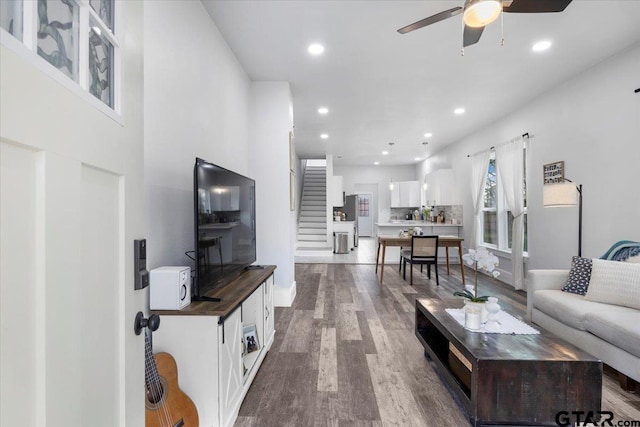 living room with wood-type flooring and ceiling fan