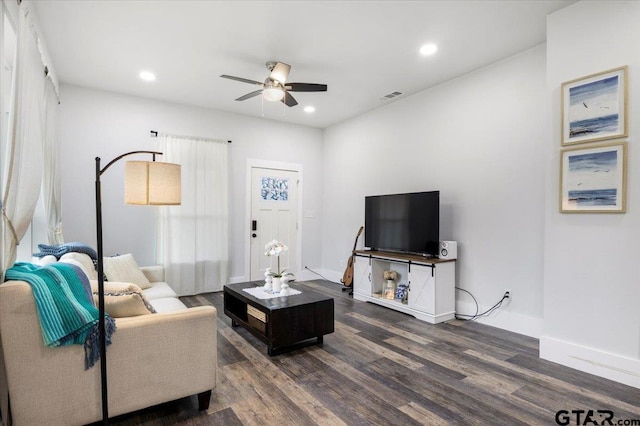 living room featuring ceiling fan and dark hardwood / wood-style flooring