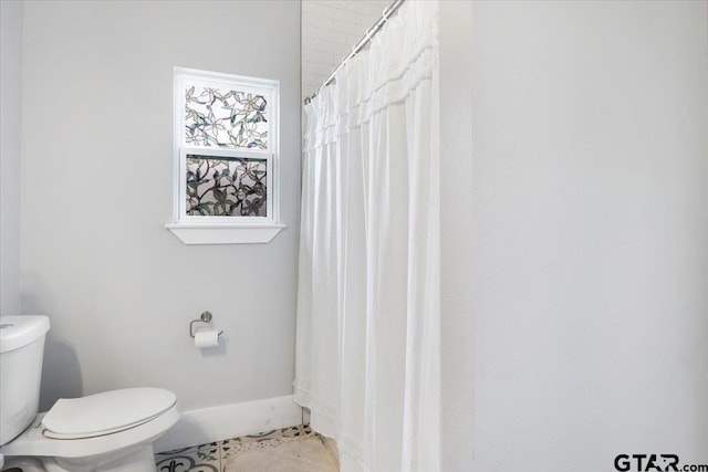 bathroom featuring a shower with curtain, tile patterned floors, and toilet