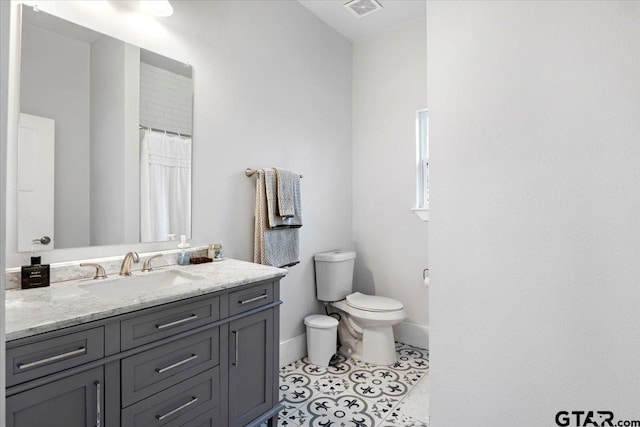 bathroom with vanity, tile patterned flooring, and toilet