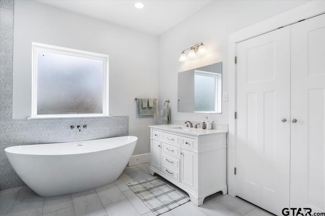 bathroom featuring a washtub, vanity, and tile patterned floors