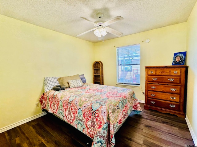 bedroom with ceiling fan, dark hardwood / wood-style floors, and a textured ceiling