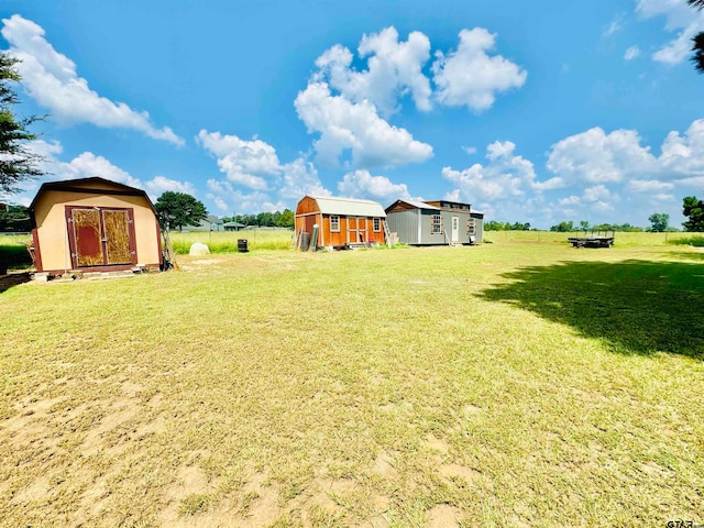 view of yard featuring a rural view and a storage shed