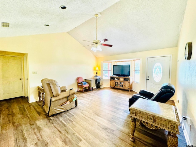 living room with a textured ceiling, high vaulted ceiling, hardwood / wood-style flooring, and ceiling fan