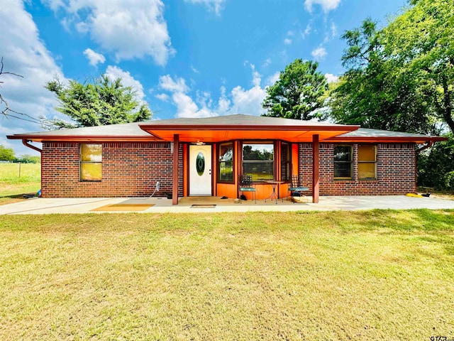 view of front of home featuring a front lawn and a patio